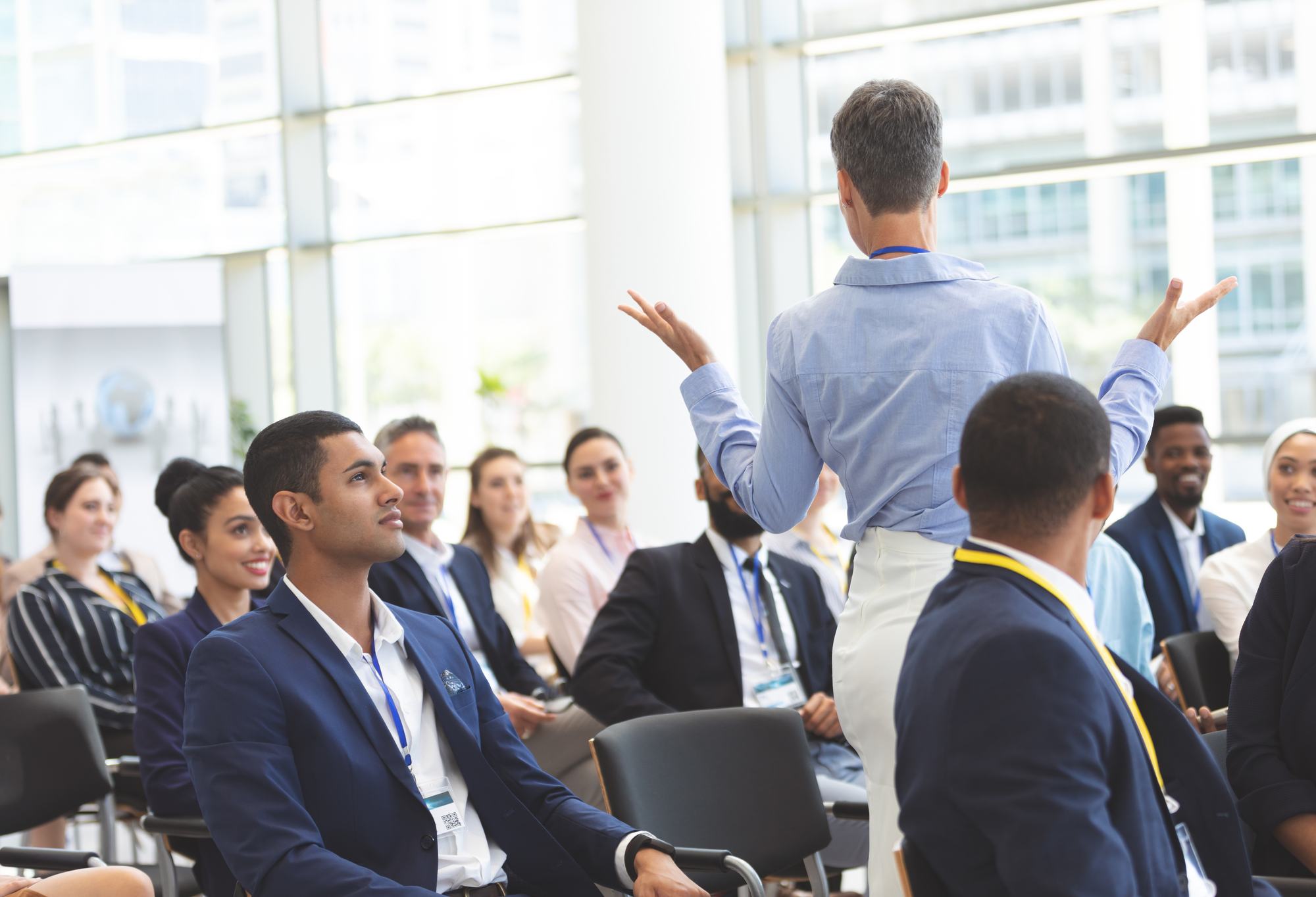 A facilitator leading a workshop for a seated group of professionals